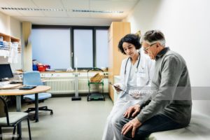 elderly man talking to his doctor about damage to arteries and veins