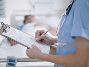 Nurse holding a clipboard while talking to a heart patient